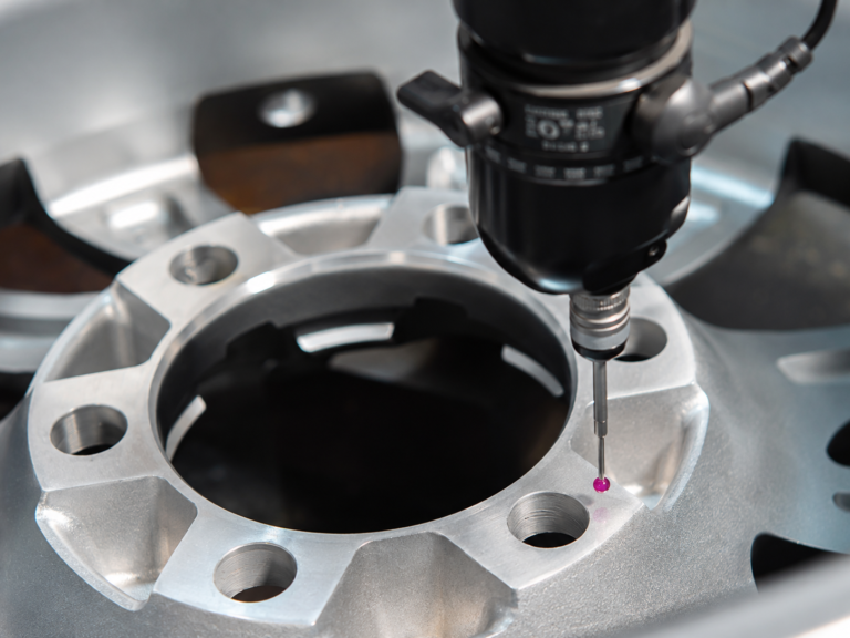 Technician measuring a forged wheel for dimensional accuracy during quality control