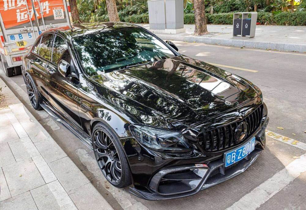 Black Mercedes-AMG sedan on factory multi-spoke AMG rims, front three-quarter view