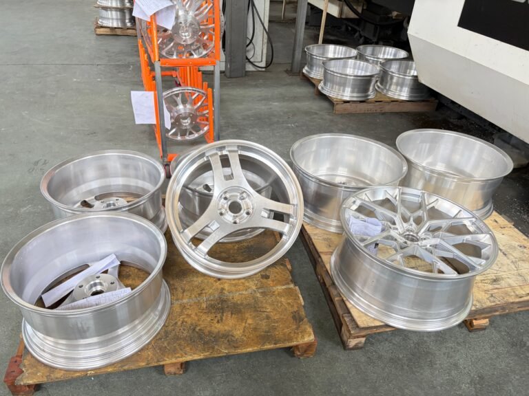 Machined forged wheels staged on the factory floor for further processing