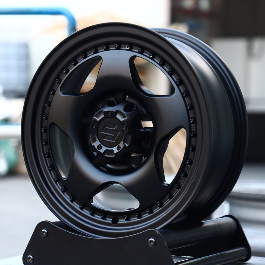 Suzuki Jimny wheels – Matte Black Semi-Full-Face Riveted Wide Lip (Suzuki OEM-Style), angled view