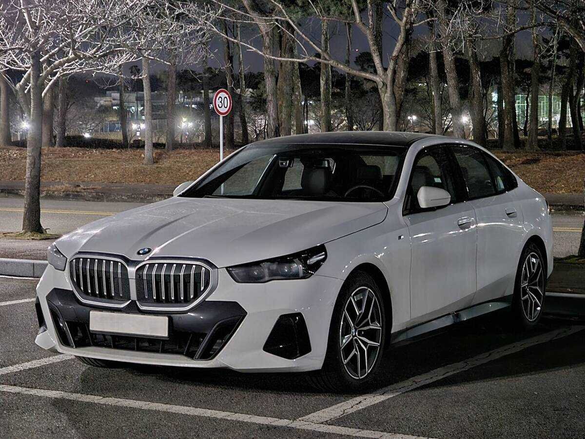 BMW 5 Series G60 520i M Sport sedan in Alpine White, front three-quarter view