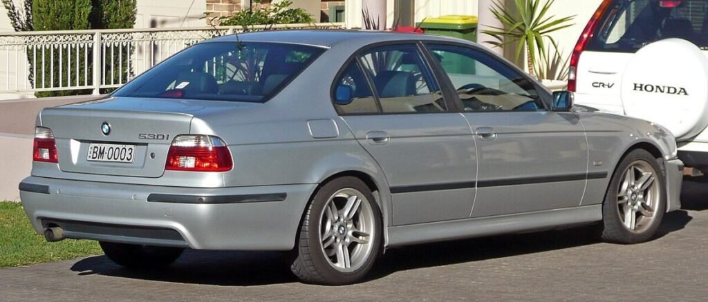 BMW 5 Series wheel specs: E39 530i sedan on factory alloy wheels, rear three-quarter view