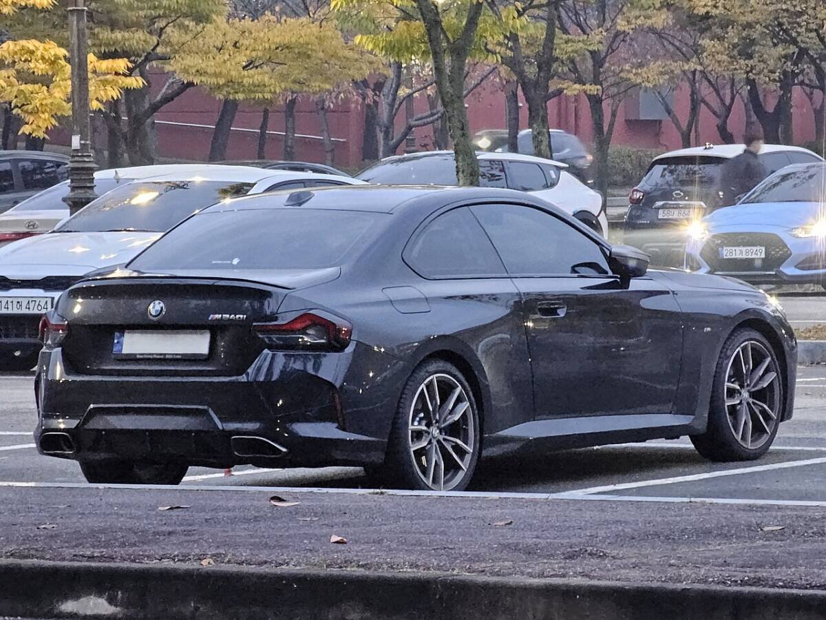 BMW M240i xDrive coupe (G42), rear three-quarter view showing the rear wheel