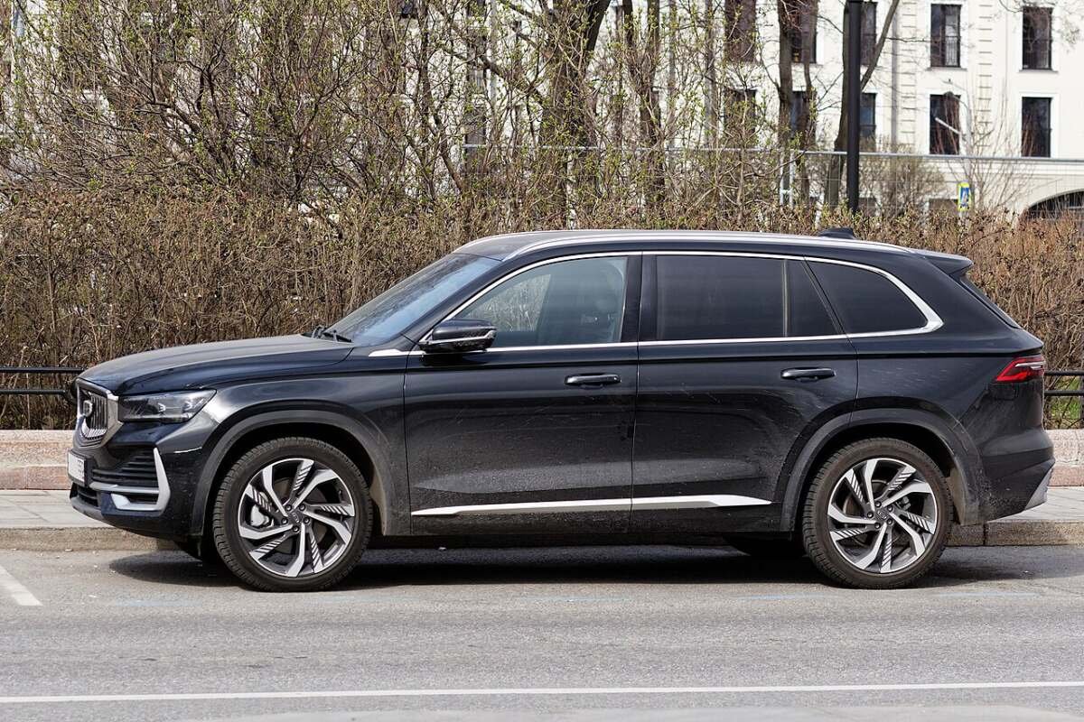 Чёрный Geely Monjaro, вид сбоку: колёсная арка, штатное колесо и посадка диска