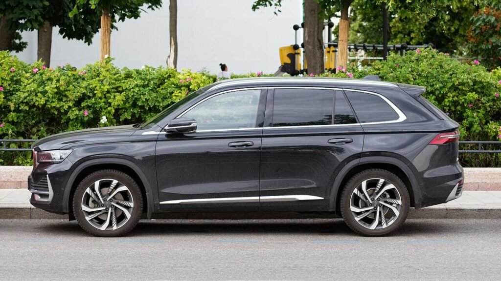 Вылет дисков Geely Monjaro: тёмно-серый кроссовер в профиль, заводские литые диски и профиль шины