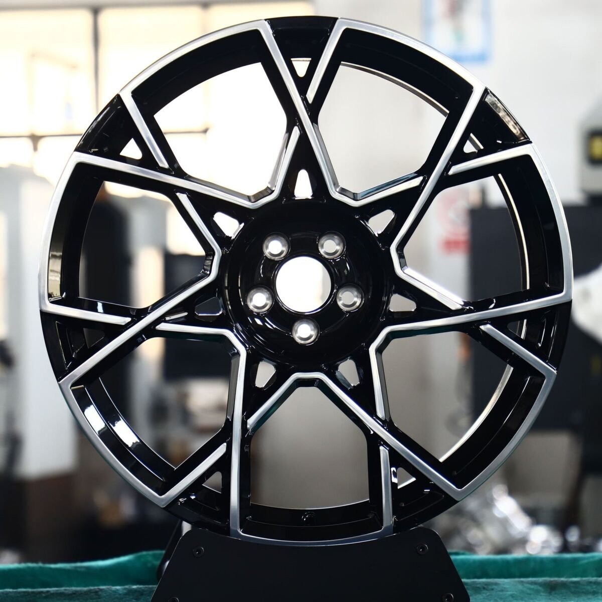 Gloss black machined monoblock forged wheel with split spokes and no seam or fasteners, front view