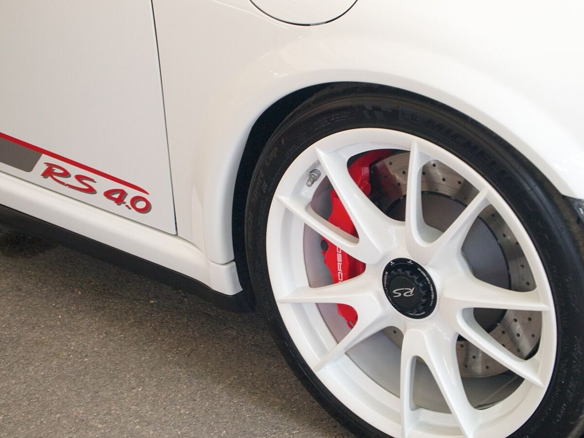 White Porsche 911 997 GT3 RS 4.0 center-lock wheel with a single central nut and red brake caliper