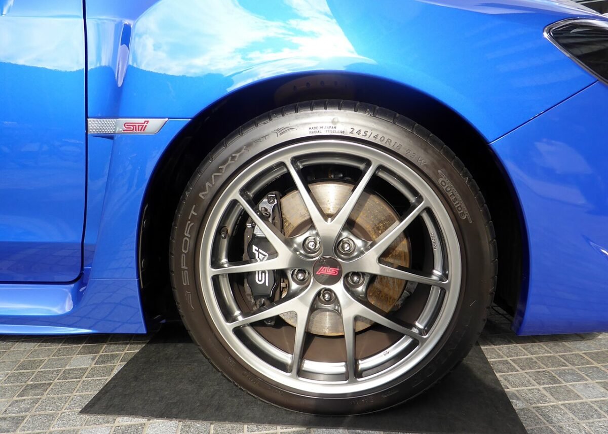 Front wheel of a Subaru WRX STI with an 18-inch spoked wheel and a Brembo caliper behind the spokes